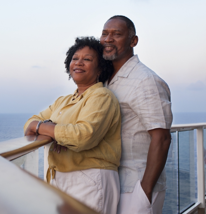 African American couple smiling looking over balcony.