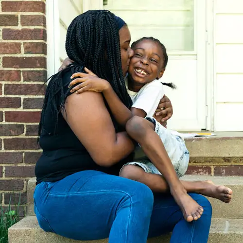 mother embracing her young child, symbolizing the care and support provided through medicaid health services.