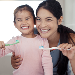 mother and daughter brushing teeth